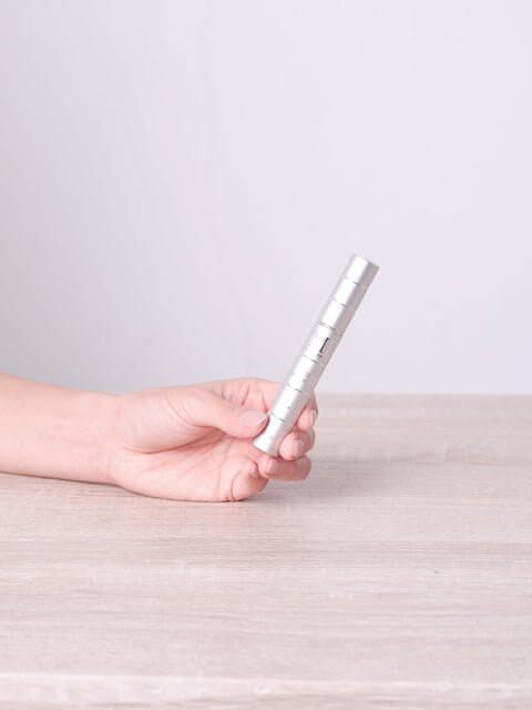 Hand holding MD Lash Factor 6-month supply eyelash conditioner for lash growth